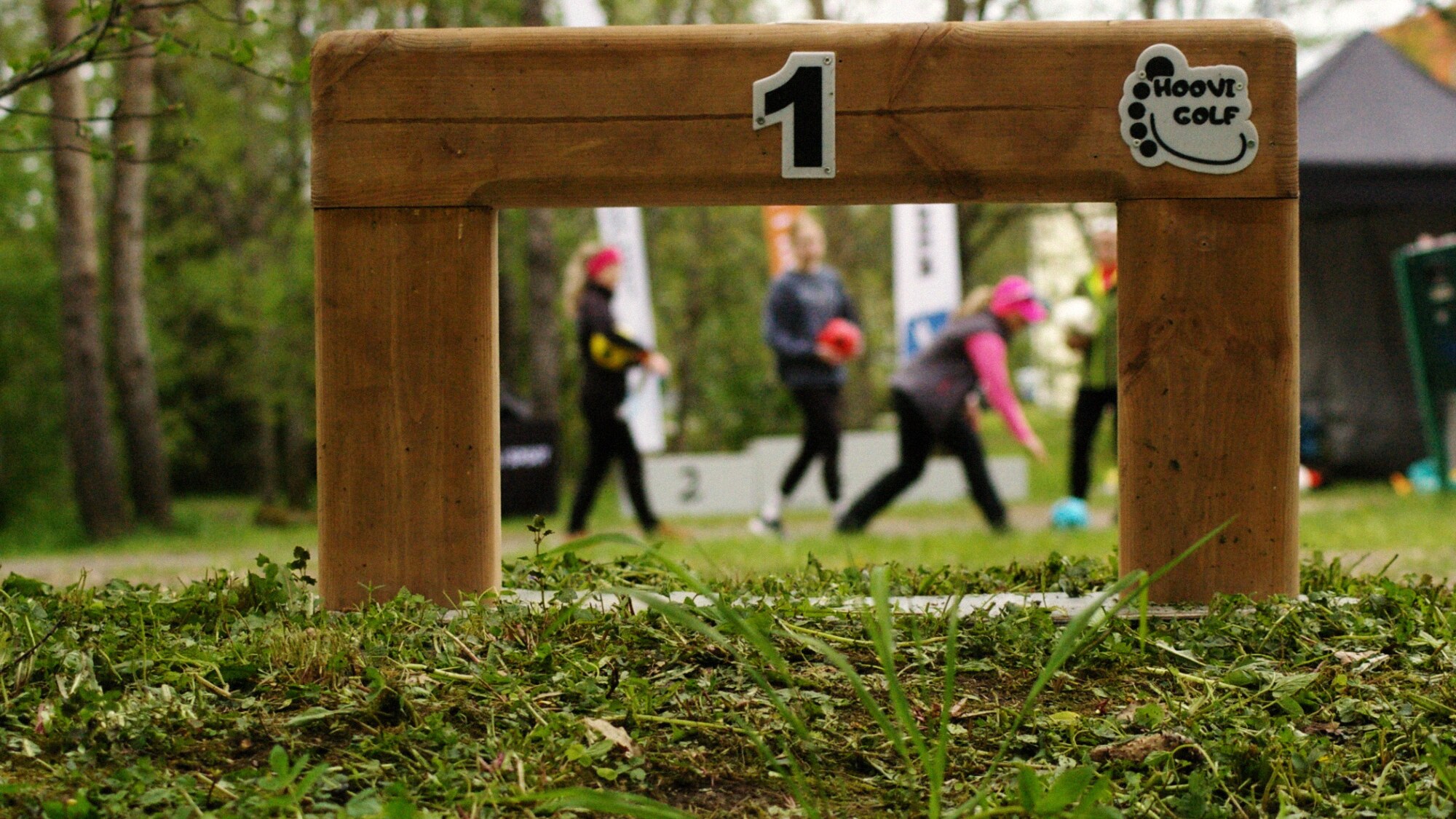 Hoovigolfi värav numbriga 1 — mängijad taustal